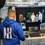 Solid Streamin teknikko miksauspöydän takana, asiakkaat studiossa.